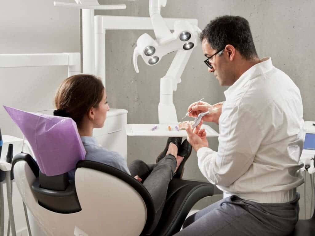Dentist explaining procedure to patient in clinic.